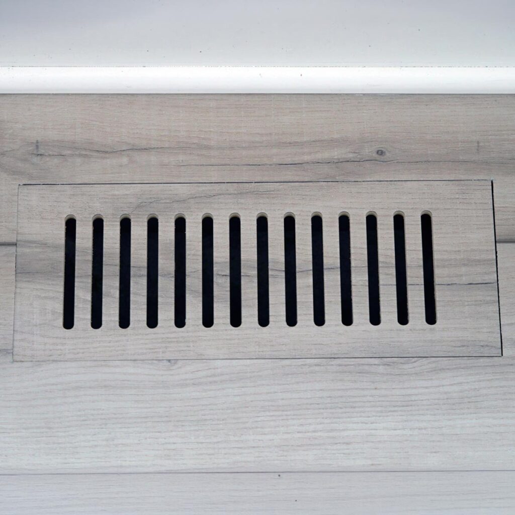 Close-up view of custom floor vent covers Chicago IL crafted from matching wood laminate material.
