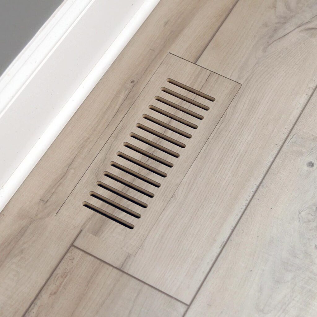 Close-up view of custom floor vent covers Colorado Springs crafted from matching wood laminate material.