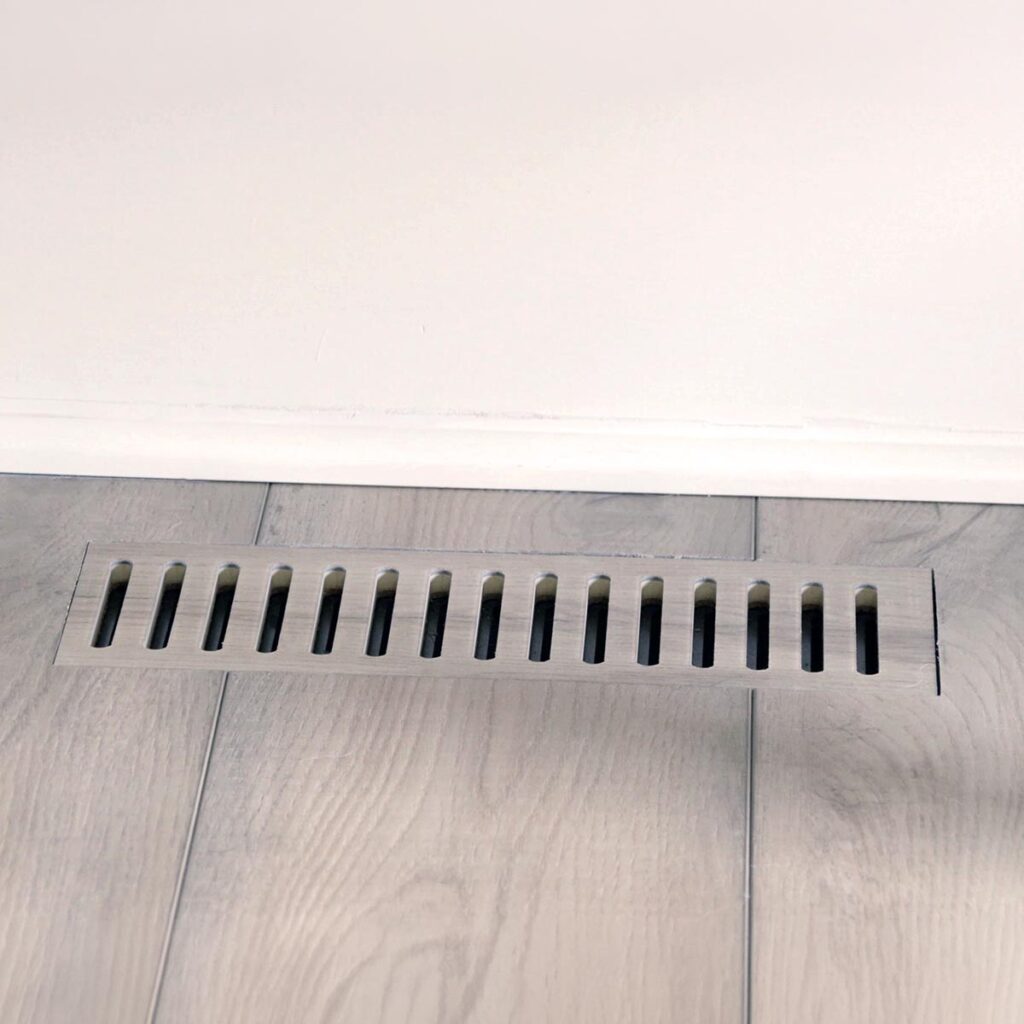 Close-up view of custom floor vent covers Denver CO crafted from matching wood laminate material