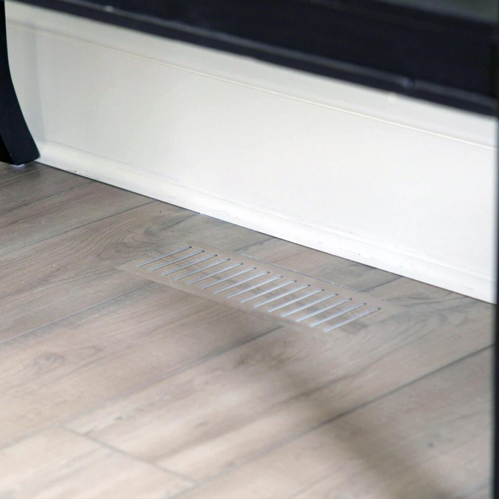 Close-up view of custom floor vent covers Lincoln NE crafted from matching wood laminate material.